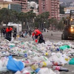 Miembros del servicio de limpieza municipal de Málaga recogen restos de basura en la playa de La Malagueta tras la celebración de la noche de San Juan