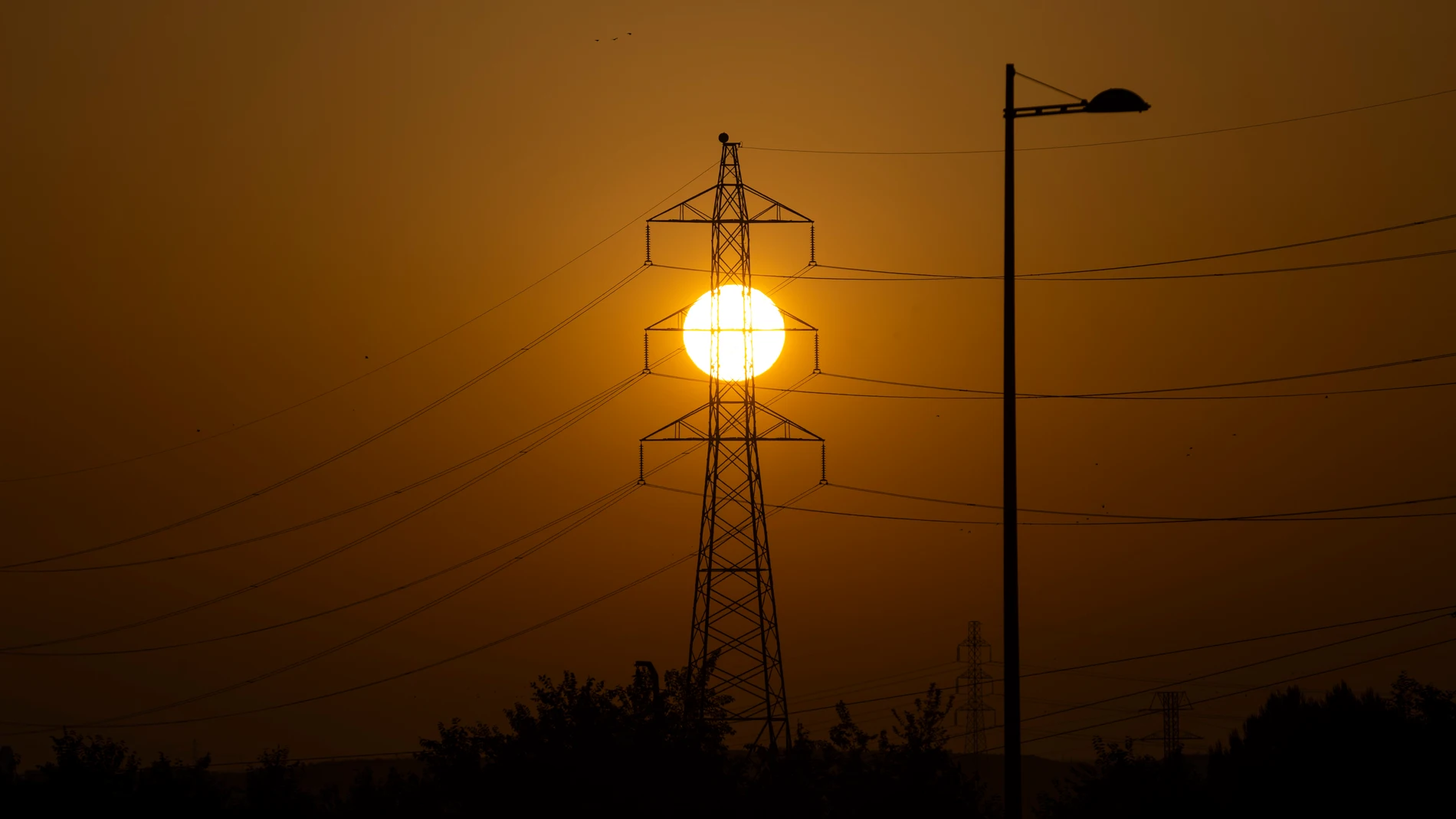 Imagen de torres de alta tensión eléctricas al amanecer en Madrid.