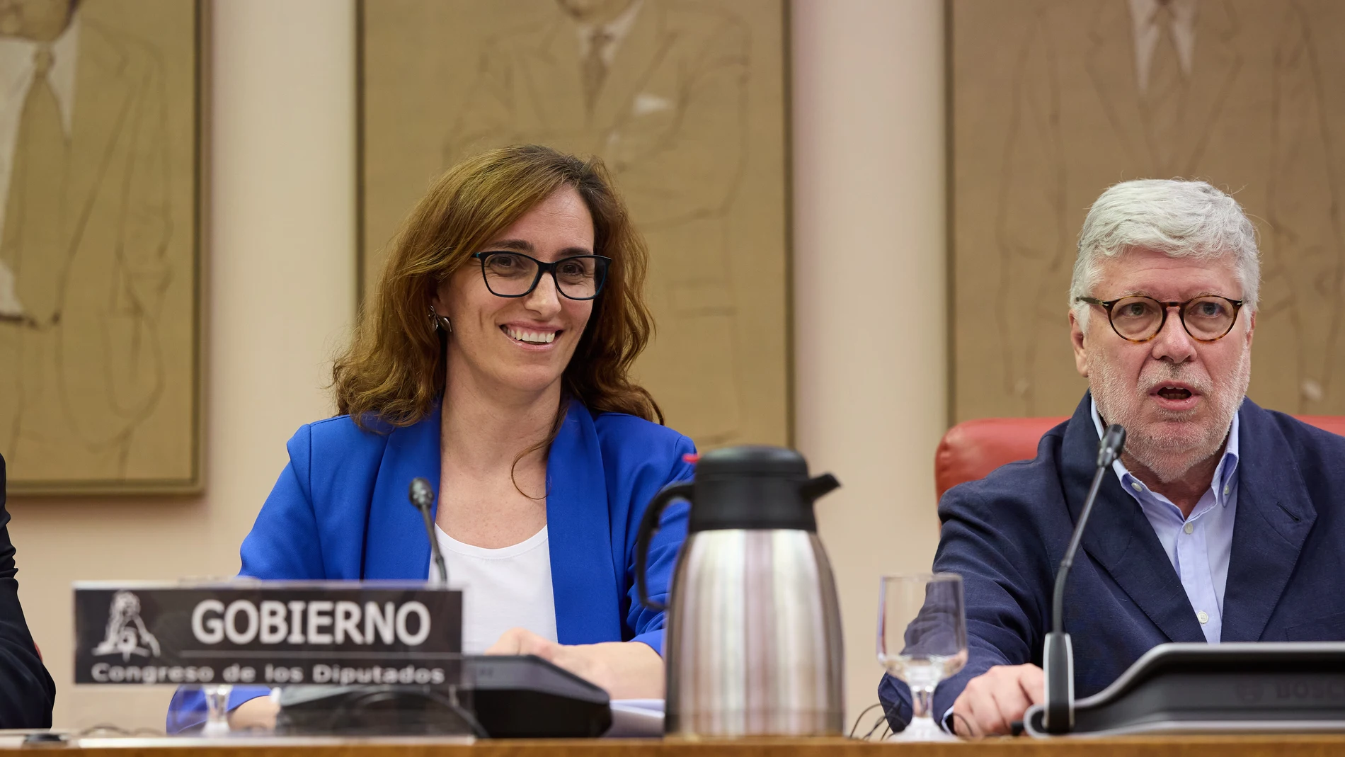 La ministra de Sanidad, Mónica García y el presidente de la Comisión, Agustín Santos, durante la Comisión de Sanidad, en el Congreso de los Diputados, a 24 de junio de 2025, en Madrid (España). La ministra ha comparecido a petición para exponer sus líneas de trabajo en la presente legislatura, así como para explicar si tiene previsto impulsar en algún momento alguna medida para solucionar las necesidades existentes actualmente en la atención primaria en el conjunto del Sistema Nacional de Sal...
