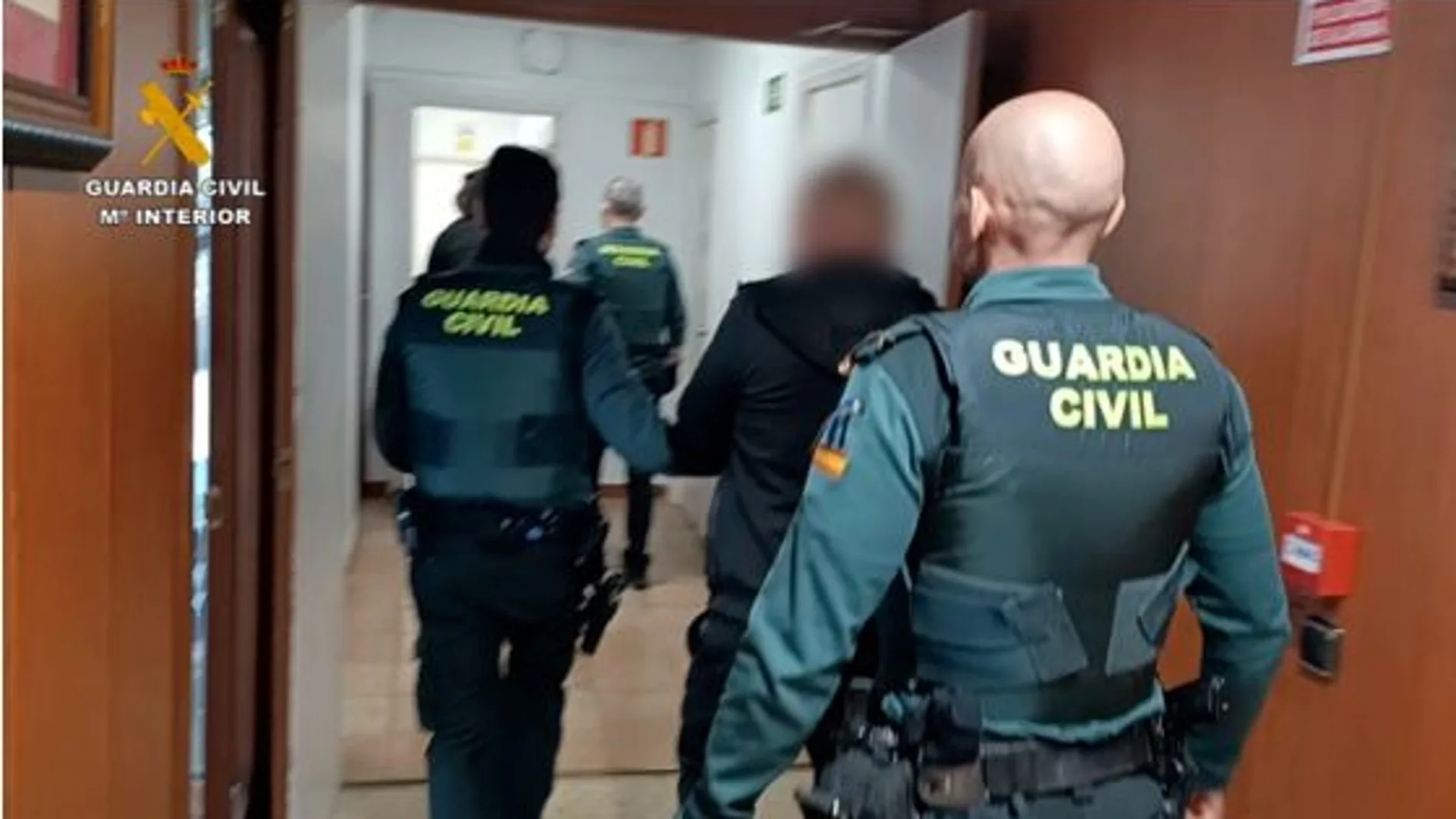 Efectivos de la Guardia Civil con uno de los detenidos