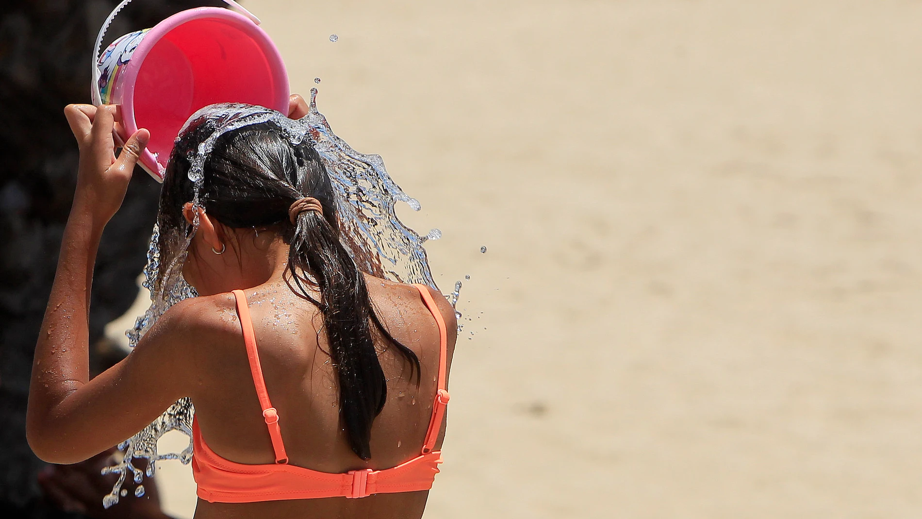 Imagen de una persona refrescándose con agua