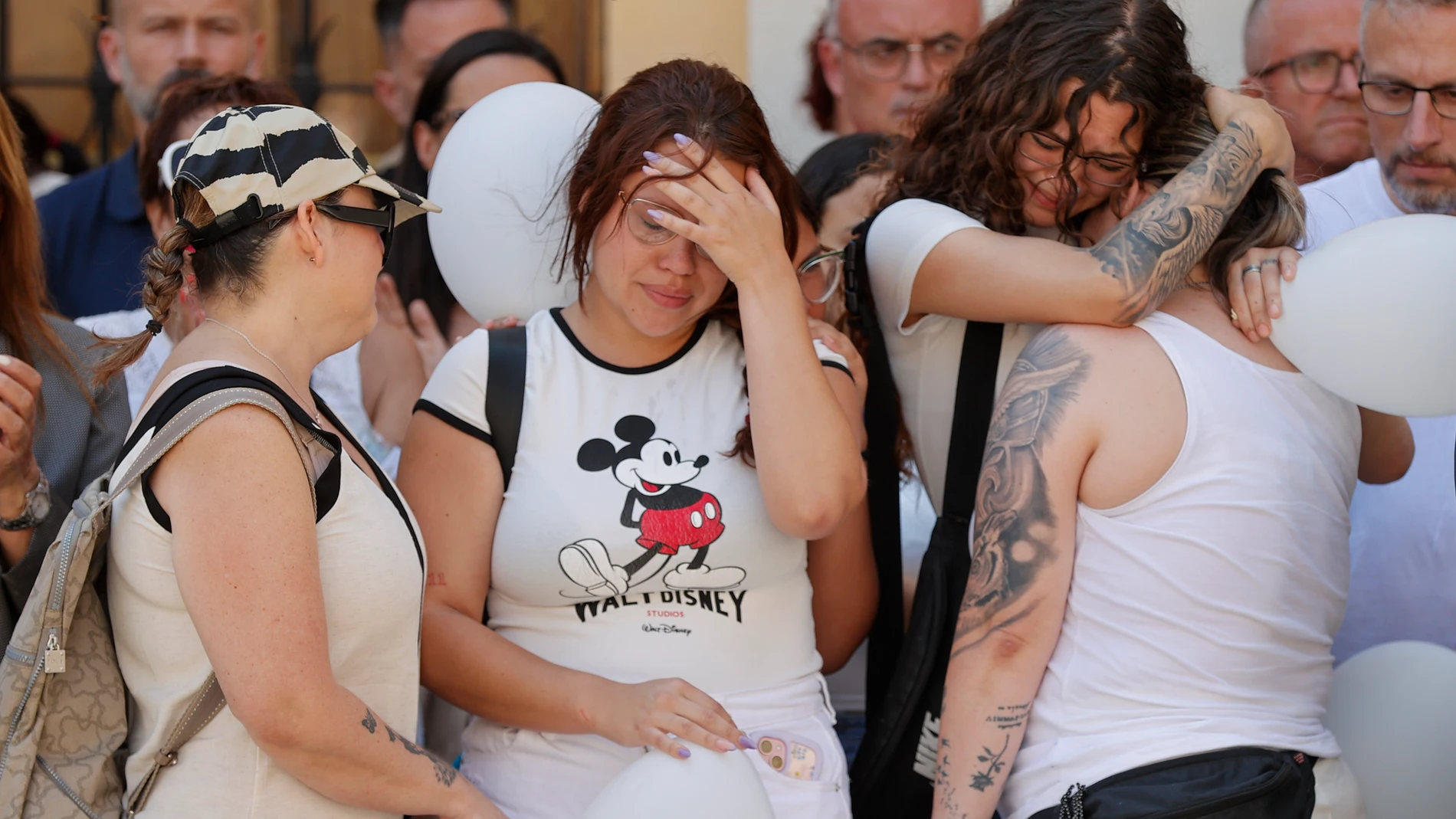 GRAFCVA8340. ALGEMESÍ (VALENCIA), 26/06/2025.- Amigas de las victimas durante el minuto de silencio convocado por el ayuntamiento de Algemesí (Valencia) para mostrar su repulsa por el asesinato de una mujer de 41 años y su hijo de dos años a manos de su pareja y padre del menor. EFE/Manuel Bruque