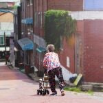 Una abuela paseando cerca de su vivienda
