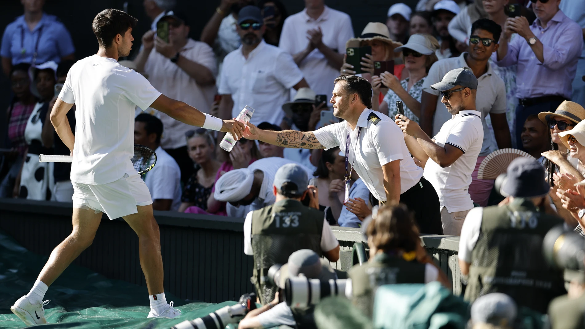 Wimbledon (United Kingdom), 30/06/2025.- Carlos Alcaraz of Spain hands over his water bottle after a spectator fainted due to the hot weather during the Men's 1st round match against Fabio Fognini of Italy at the Wimbledon Championships, Wimbledon, Britain, 30 June 2025. (Tenis, Italia, España, Reino Unido) EFE/EPA/TOLGA AKMEN EDITORIAL USE ONLY EDITORIAL USE ONLY