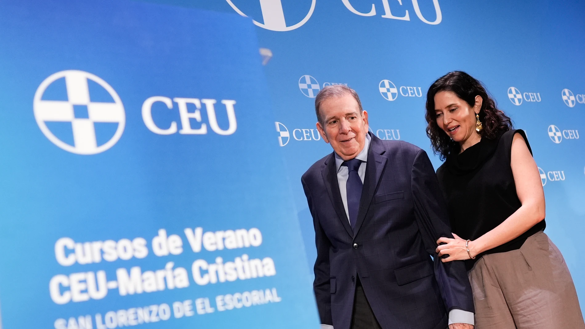 MADRID, 30/06/2025.- La presidenta de la Comunidad de Madrid, Isabel Díaz Ayuso (d), junto al líder opositor venezolano Edmundo González Urrutia (i), durante la inauguración de los Cursos de Verano CEU-María Cristina, que han dado comienzo este lunes en un acto celebrado en el Real Centro Universitario Escorial-María Cristina de San Lorenzo de El Escorial, donde se llevarán a cabo los 14 cursos del ciclo, que abordarán temas de ámbito social, cultural, político, educativo y religioso, e inclu...