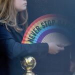 Una joven con un abanico reivindicativo del Orgullo