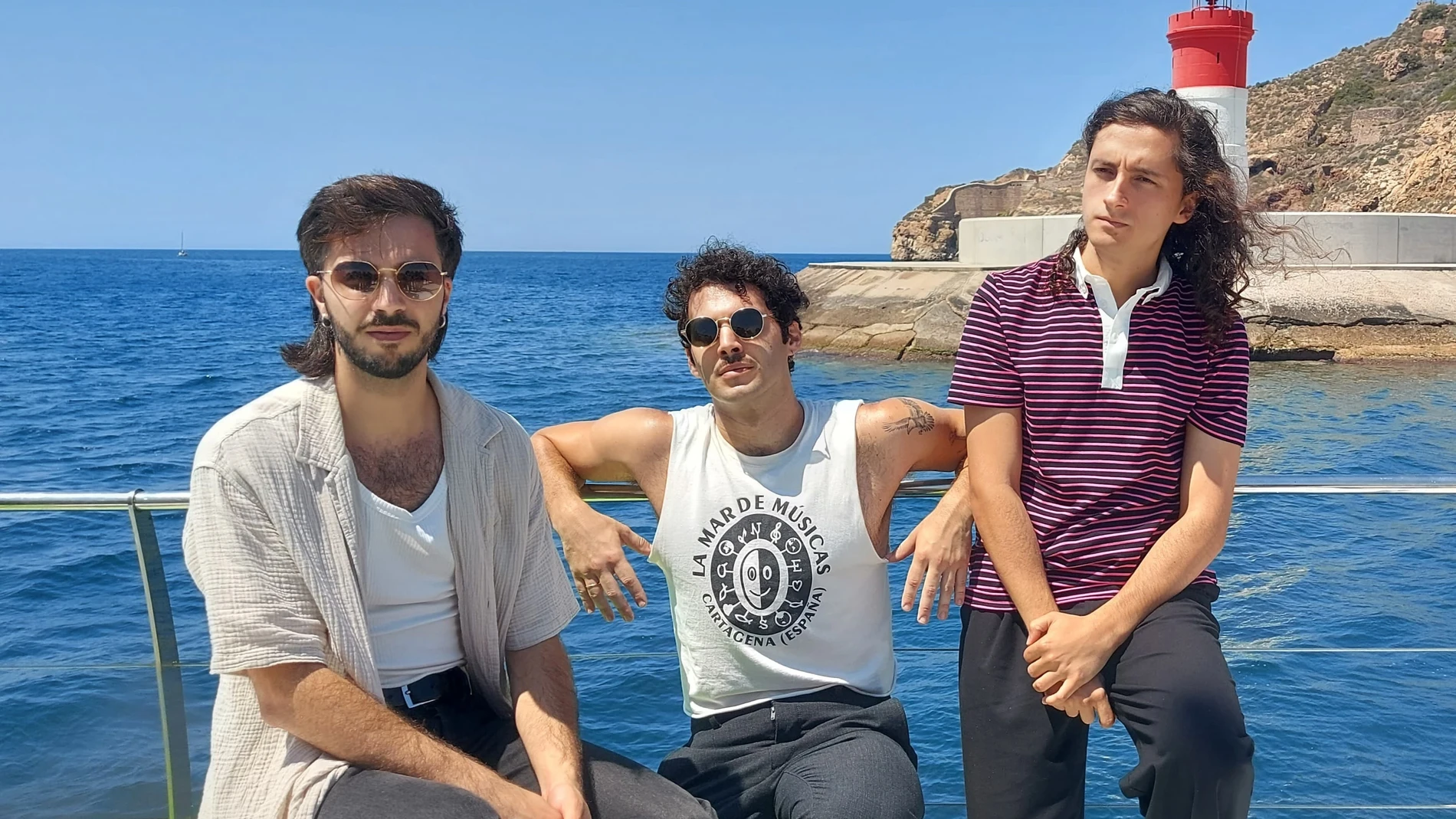 Daniel Sánchez (guitarra), Jota Mercader (batería) y Antonio García, (cantante) durante el recorrido en catamarán por el puerto de Cartagena EUROPA PRESS 01/07/2025