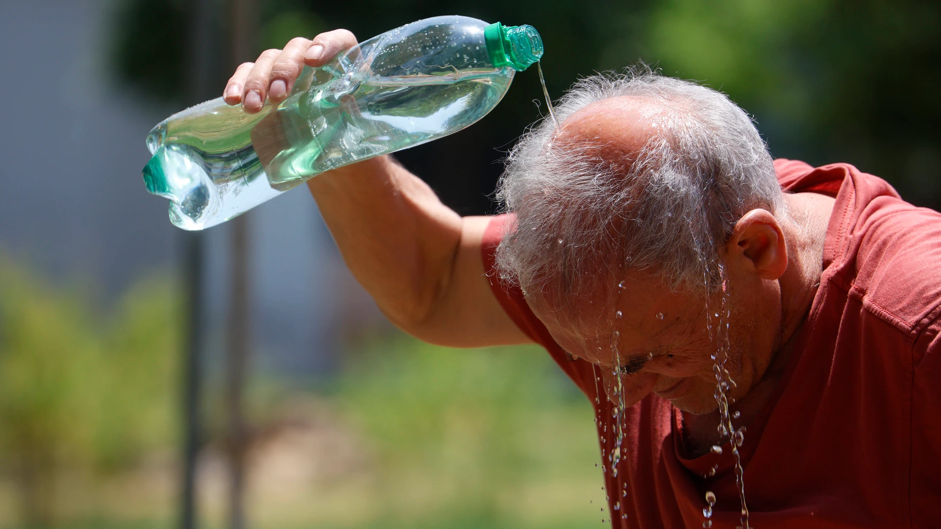 GRAFAND9840. CÓRDOBA, 01/07/2025.-Un hombre se refresca con agua de una botella en la calle en Córdoba marca 43 grados este martes en el que continúa la ola de calor un día más con todo el país en alerta ante la previsión de máximas este martes de hasta 43 grados en puntos de Andalucía. EFE/Salas