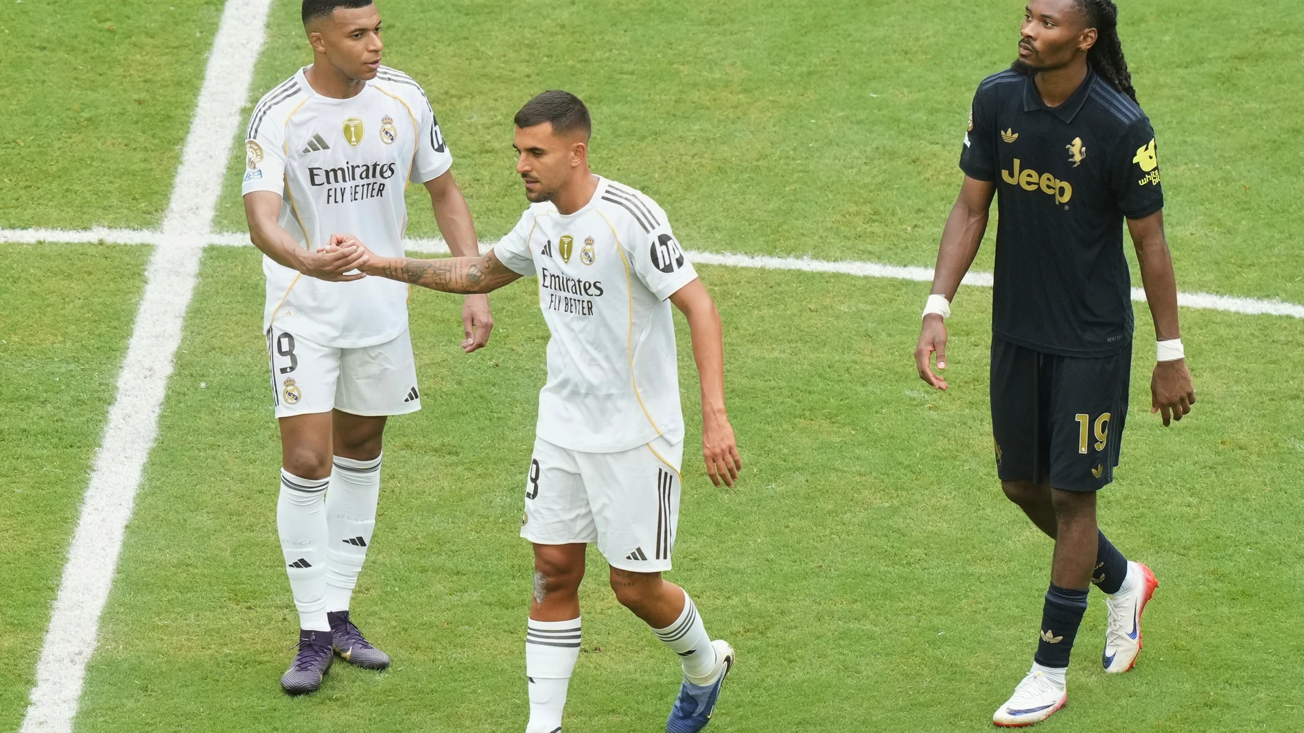 Real Madrid's Kylian Mbappe (9) greets teammate Dani Ceballos (19) as Juventus' Khephren Thuram (19) looks on after the Club World Cup round of 16 soccer match between Real Madrid and Juventus in Miami Gardens, Fla., Tuesday, July 1, 2025. (AP Photo/Marta Lavandier)