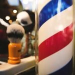 ¿Qué significa el poste giratorio de colores que aparece en las barberías?
