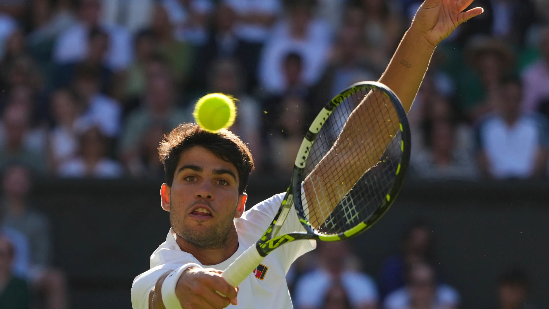 Carlos Alcaraz of Spain returns the ball to Oliver Tarvet of Britain in his second round men's singles match at the Wimbledon Tennis Championships in London, Wednesday, July 2, 2025.(AP Photo/Kirsty Wigglesworth)