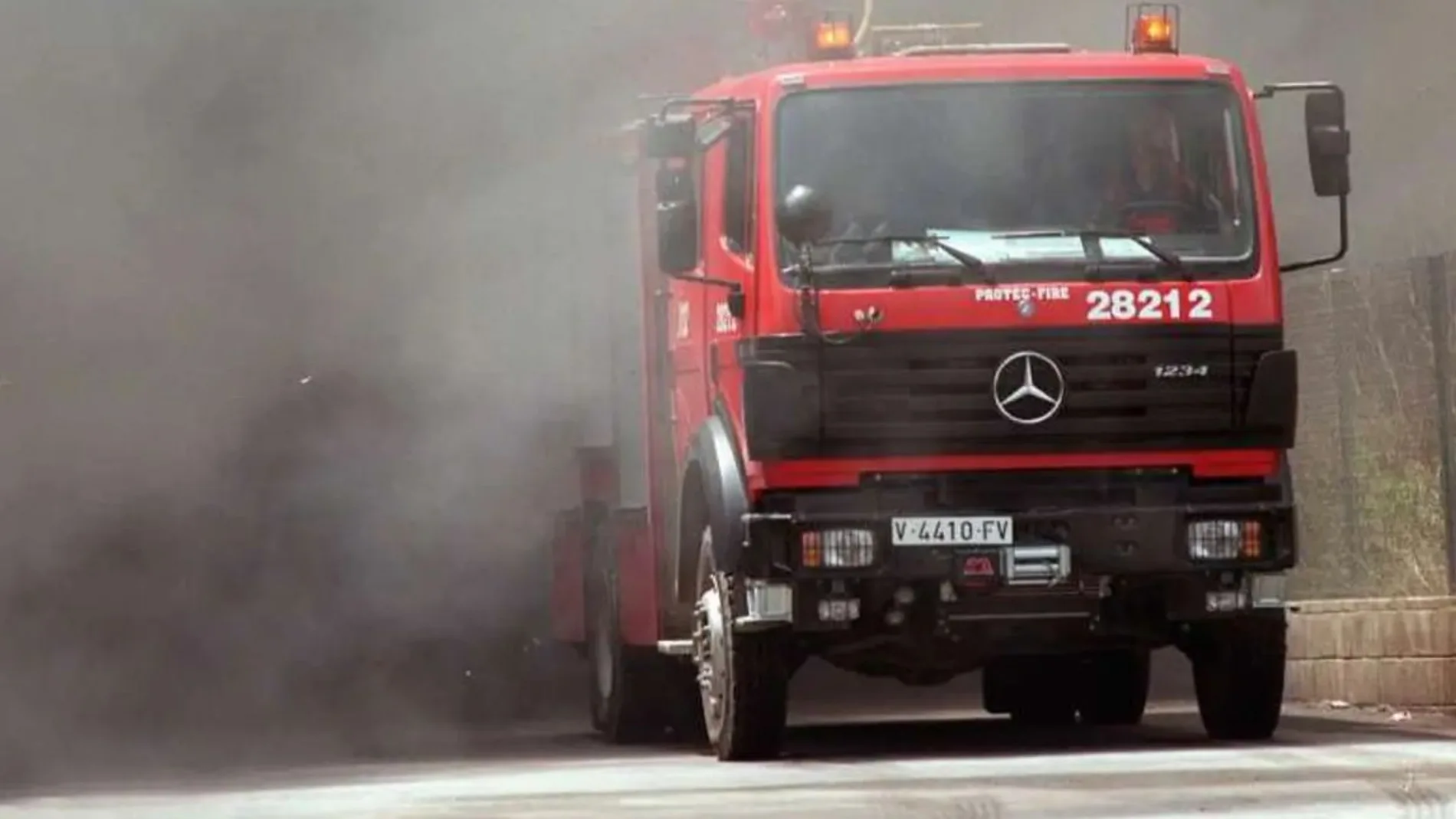 Un camión de bomberos entre una gran humareda.