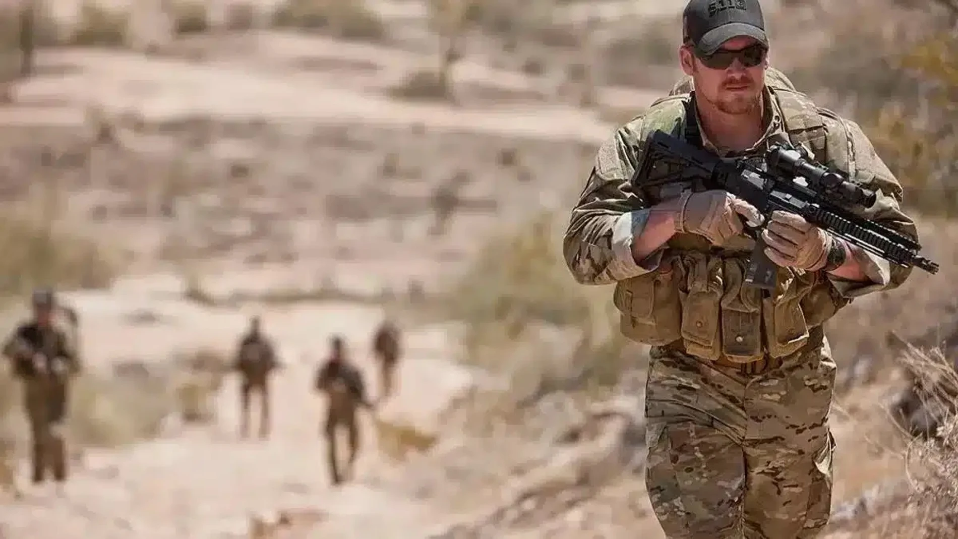Soldado del ejército norteamericano en primer plano junto a otros compañeros que caminan detrás de él