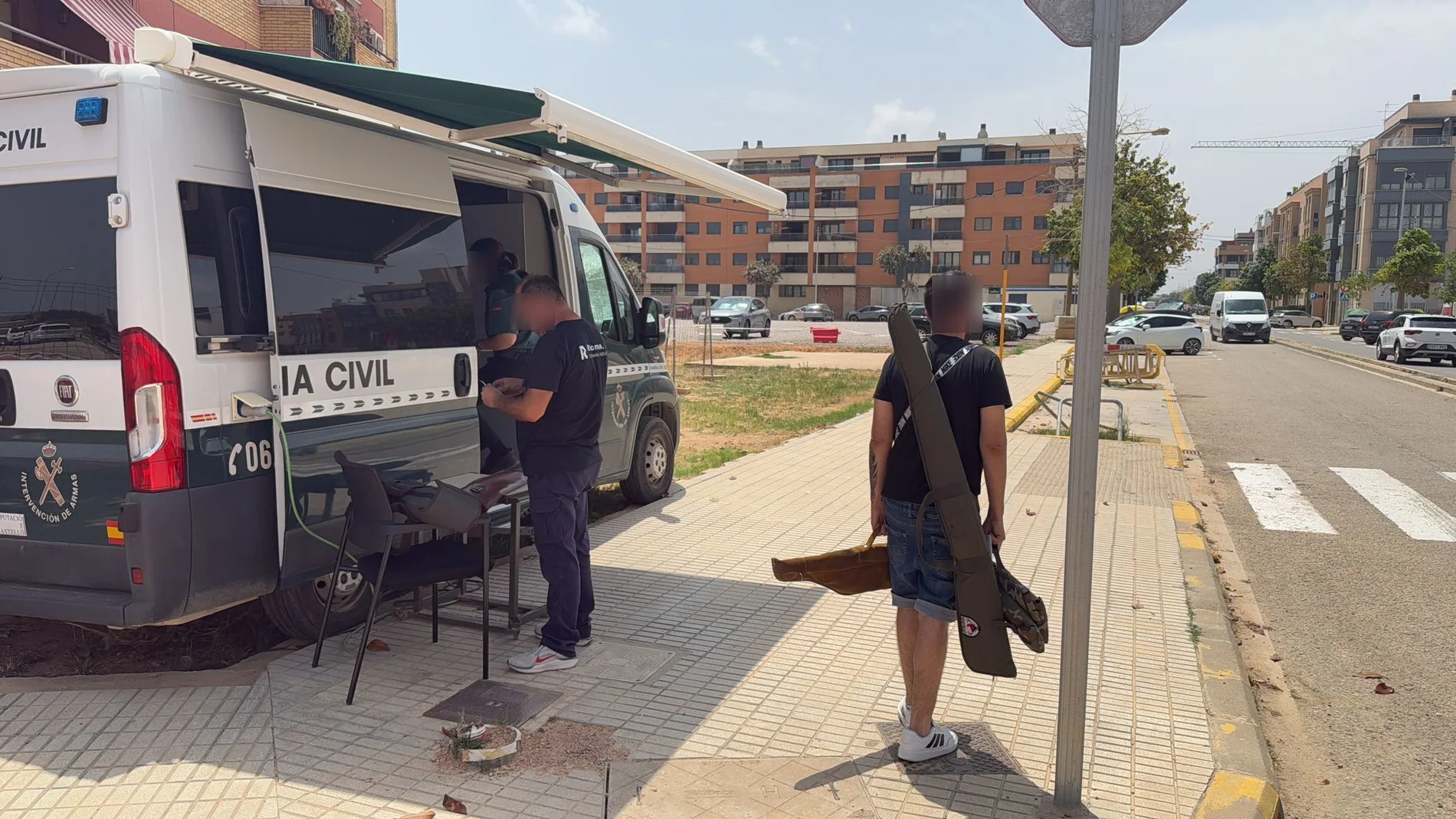 Un hombre porta armas a una oficina móvil de la Guardia Civil, en Paiporta