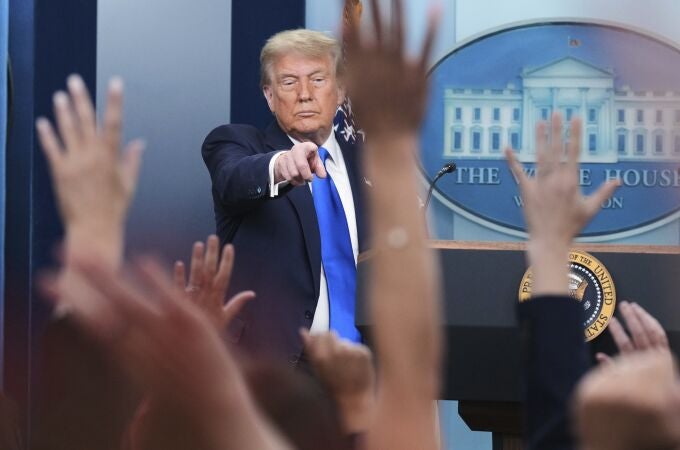 President Donald Trump points to a reporter to answer questions, in the briefing room of the White House in Washington.