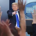 President Donald Trump points to a reporter to answer questions, in the briefing room of the White House in Washington.