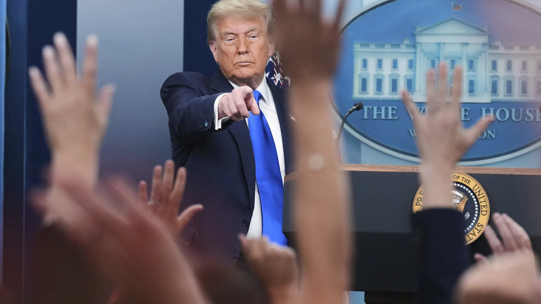 President Donald Trump points to a reporter to answer questions, in the briefing room of the White House in Washington.