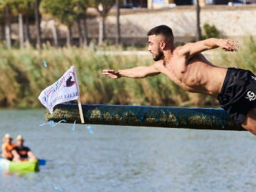 Un participante coge la bandera de la Cucaña 