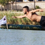 Un participante coge la bandera de la Cucaña 