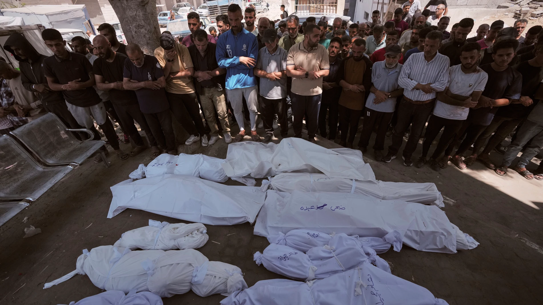 Mourners pray beside the bodies of Palestinians that were killed by an Israeli airstrike that struck a school used as a shelter, in Shifa Hospital in Gaza City, on Thursday, July 3, 2025. (AP Photo/Jehad Alshrafi)