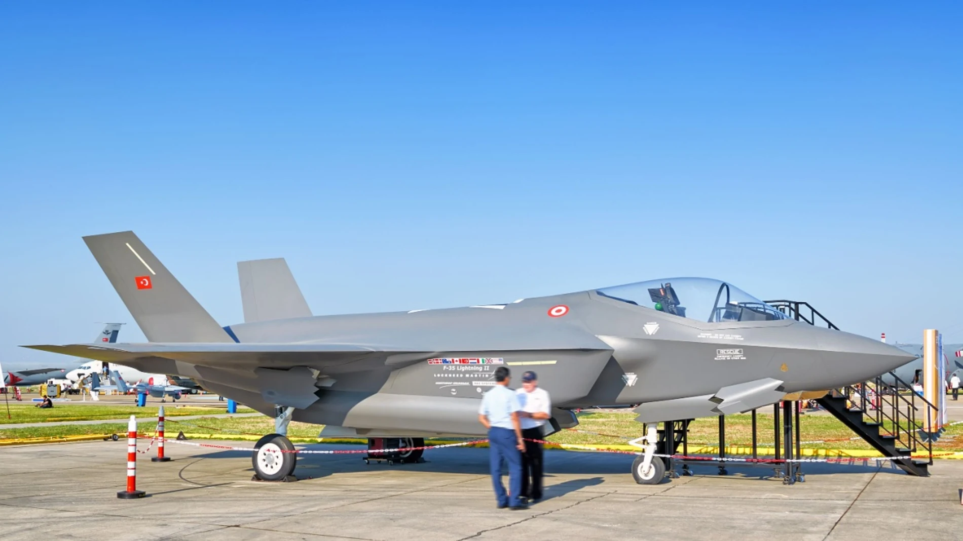 Un avión de combate aparcado y con una escalerilla para poder entrar dentro de él