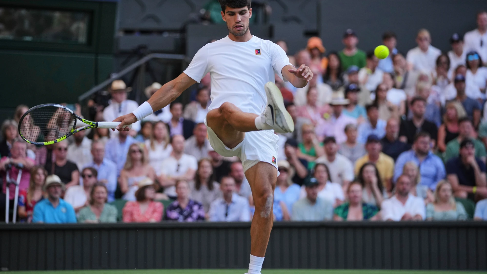 Carlos Alcaraz of Spain kicks the ball after missing a shot against Jan-Lennard Struff of Germany during a third round men's singles match at the Wimbledon Tennis Championships in London, Friday, July 4, 2025. (AP Photo/Kin Cheung)