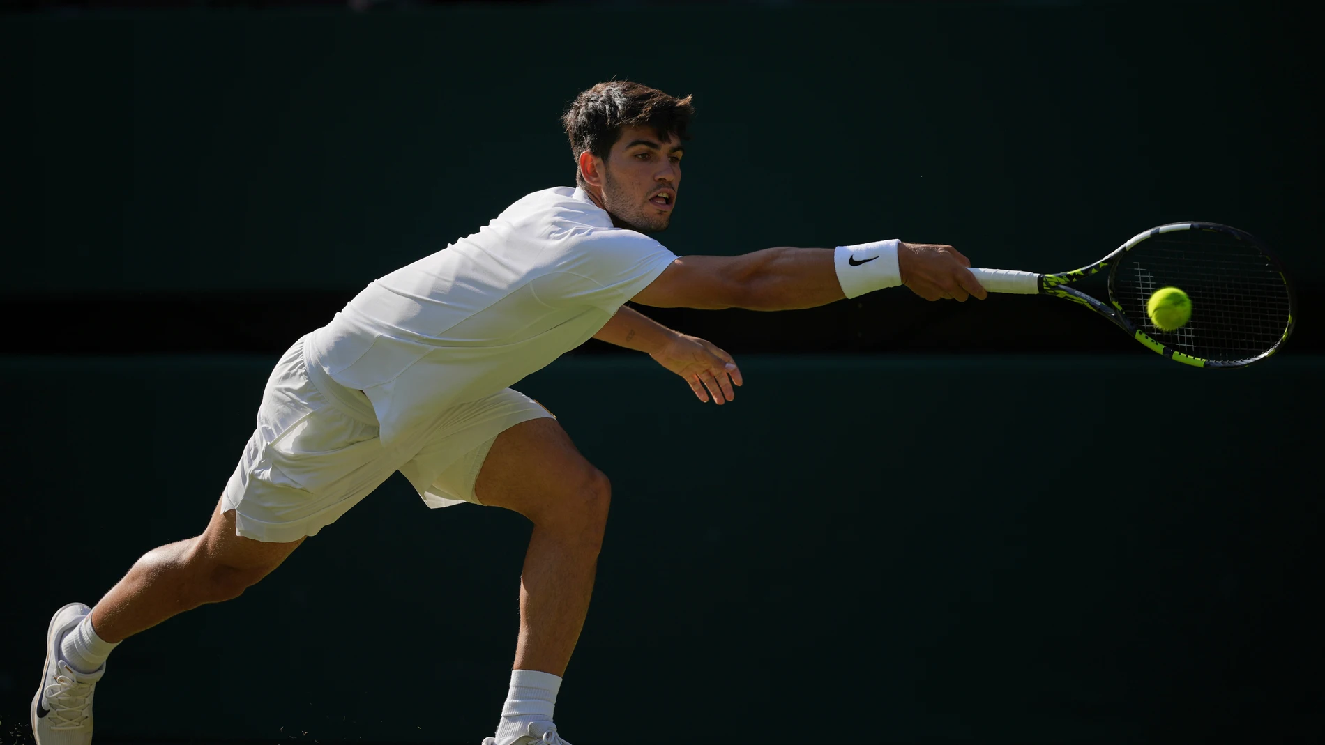 Carlos Alcaraz of Spain returns to Jan-Lennard Struff of Germany during a third round men's singles match at the Wimbledon Tennis Championships in London, Friday, July 4, 2025. (AP Photo/Kin Cheung)