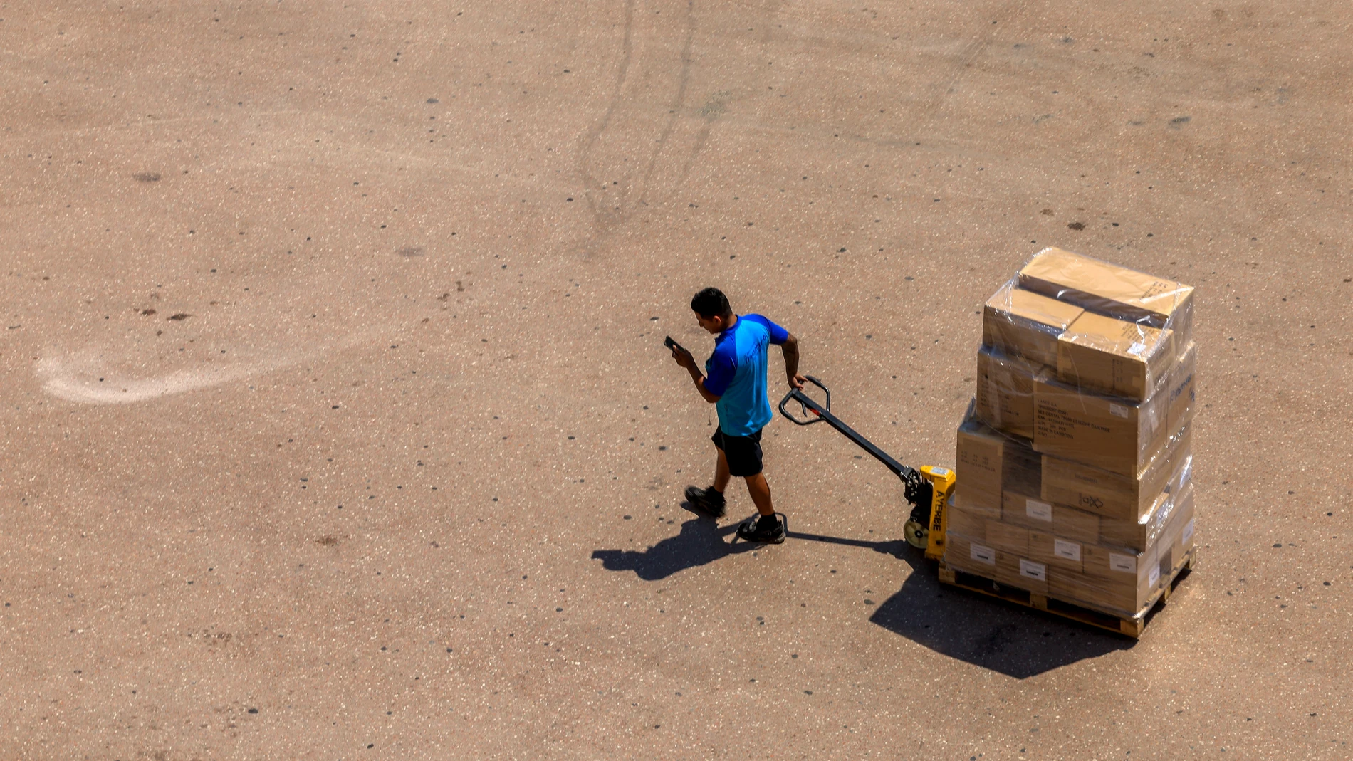 VALENCIA, 04/07/2025.- Un hombre transporta varias cajas, este viernes en Valencia. Las altas temperaturas de los últimos días darán una tregua este fin de semana en el norte peninsular, en donde se prevé un descenso térmico con ambiente que será incluso fresco para la época, mientras que el sur continuará bajo el agobiante calor intenso de los últimos días. EFE/ Kai Forsterling