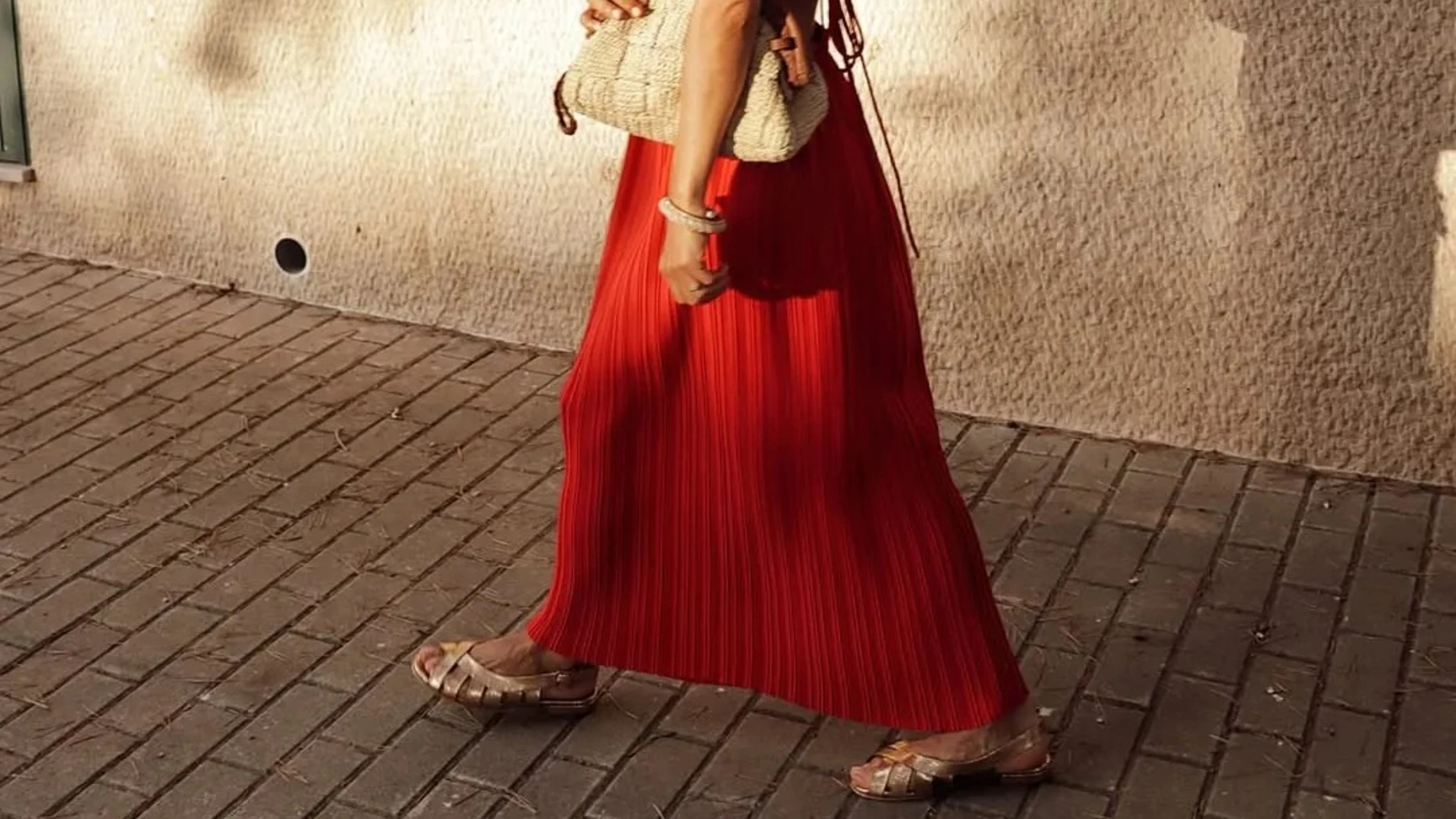 Chica con falda roja y sandalias planas tipo peeptoe en dorado