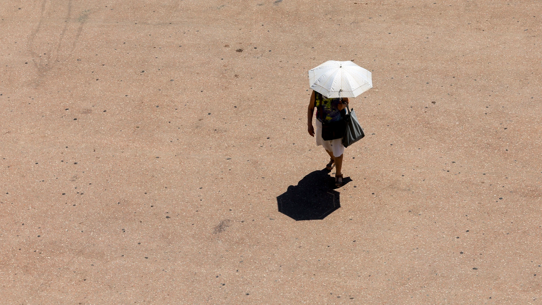 FOTODELDÍA VALENCIA, 04/07/2025.- Una mujer se protege del sol con un paraguas, este viernes en Valencia. Las altas temperaturas de los últimos días darán una tregua este fin de semana en el norte peninsular, en donde se prevé un descenso térmico con ambiente que será incluso fresco para la época, mientras que el sur continuará bajo el agobiante calor intenso de los últimos días. EFE/ Kai Forsterling