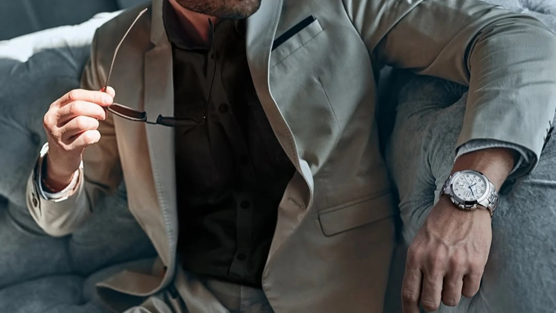Hombre elegante con traje y reloj de la marca Jaguar