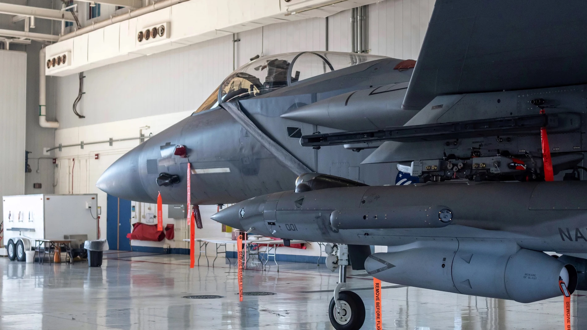 Un avión de combate cargado de misiles en un hangar militar