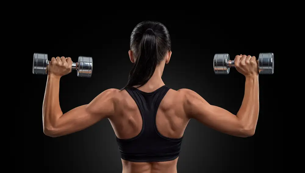 Mujer entrenando entrenando con pesas y ejercicios de fuerza