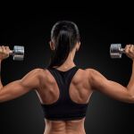 Mujer entrenando entrenando con pesas y ejercicios de fuerza