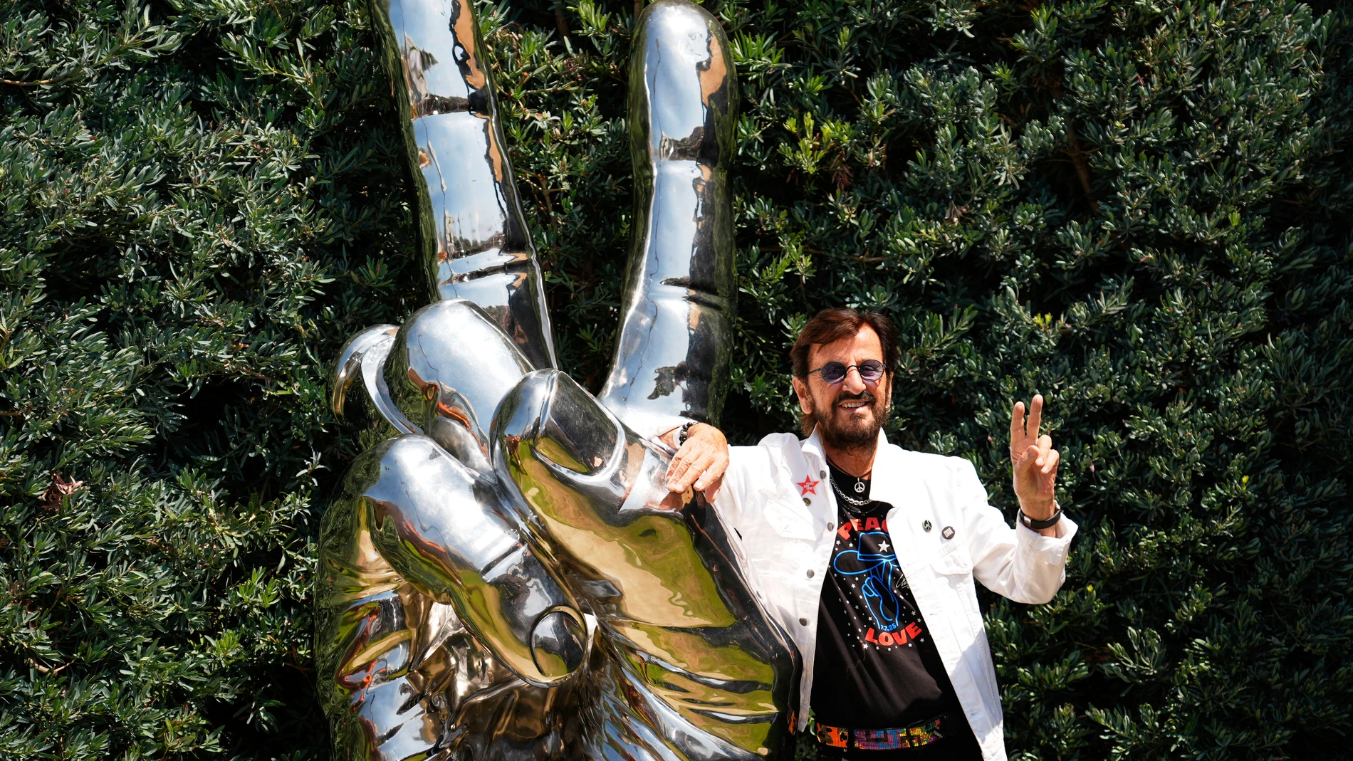Ringo Starr poses beside the "Peace & Love" sculpture during a celebration of his 85th birthday on Monday, July 7, 2025, in Beverly Hills, Calif. (AP Photo/Chris Pizzello)