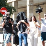 El denunciado y supuesto agresor (c) que ha cambiado de sexo para tratar de eludir un juicio por violencia machista, a la salida del juzgado tras declarar.