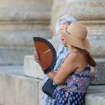 Dos mujeres abanicándose en la calle. 