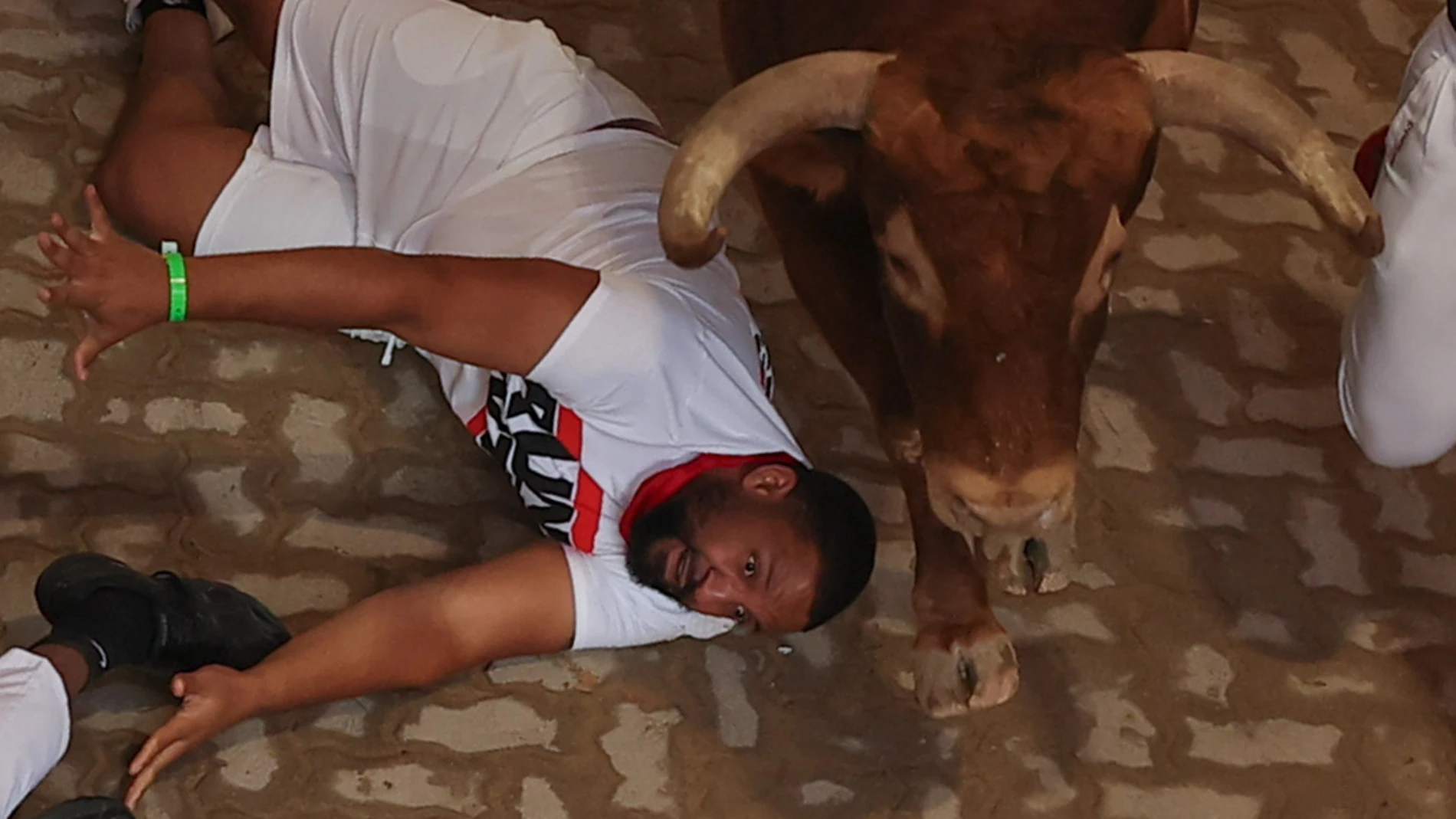 PAMPLONA, 09/07/2025.- Un corredor cae al paso de uno de los toros de la ganadería Álvaro Núñez en el callejón de entrada a la Plaza de Toros durante el tercer encierro de los Sanfermines 2025 este miércoles en Pamplona. EFE/ J. P. Urdioz