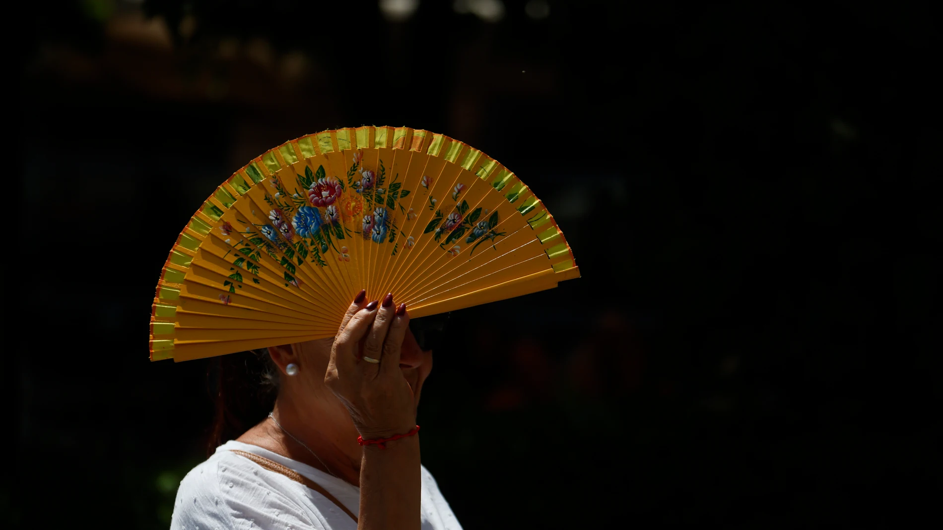 GRAFAND9967. CÓRDOBA, 09/07/2025.-Una mujer se tapa con un abanico mientras camina por el centro histórico, este miércoles cuando se mantiene el aviso amarillo en Córdoba, donde se alcanzarán los 40 grados. Según los datos de la Agencia Estatal de Meteorología (Aemet) sitúan al valle del Guadalquivir, entre las provincias de Jaén y Córdoba, como la zona más calurosa del país puesto que no hay precedentes de que una comarca haya recibido durante 31 días consecutivos (en concreto desde el pasad...