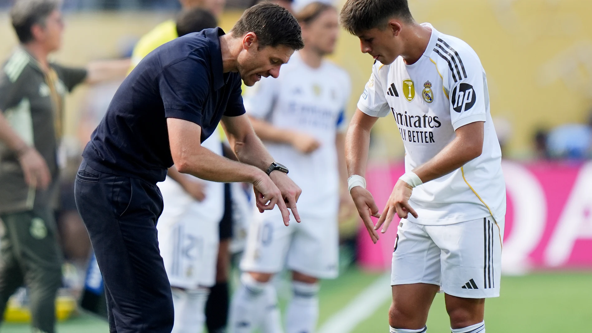 Real Madrid manager Xabi Alonso, left, talks with Arda Guler during the second half of a Club World Cup semifinal soccer match against Paris Saint-Germain in East Rutherford, N.J., Wednesday, July 9, 2025. (AP Photo/Frank Franklin II)
