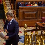 Feijóo se dirige al atril con Pedro Sánchez detrás, en el Pleno del Congreso de los Diputados