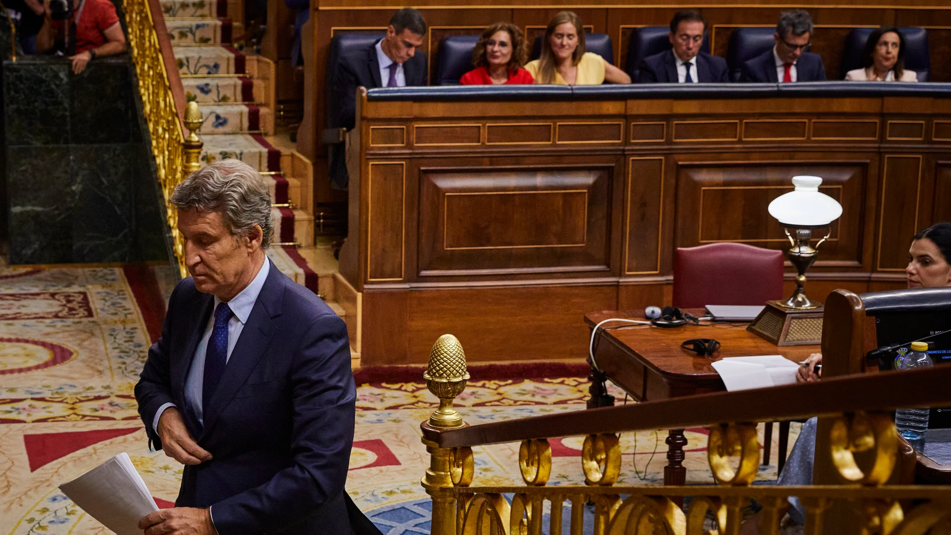 Feijóo se dirige al atril con Pedro Sánchez detrás, en el Pleno del Congreso de los Diputados