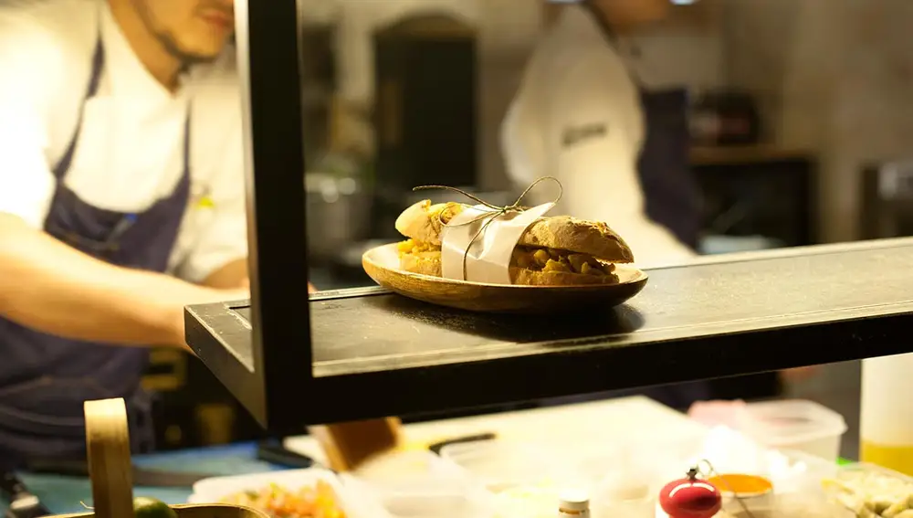 Detalle la cocina de la taberna con uno de sus bocadillos.