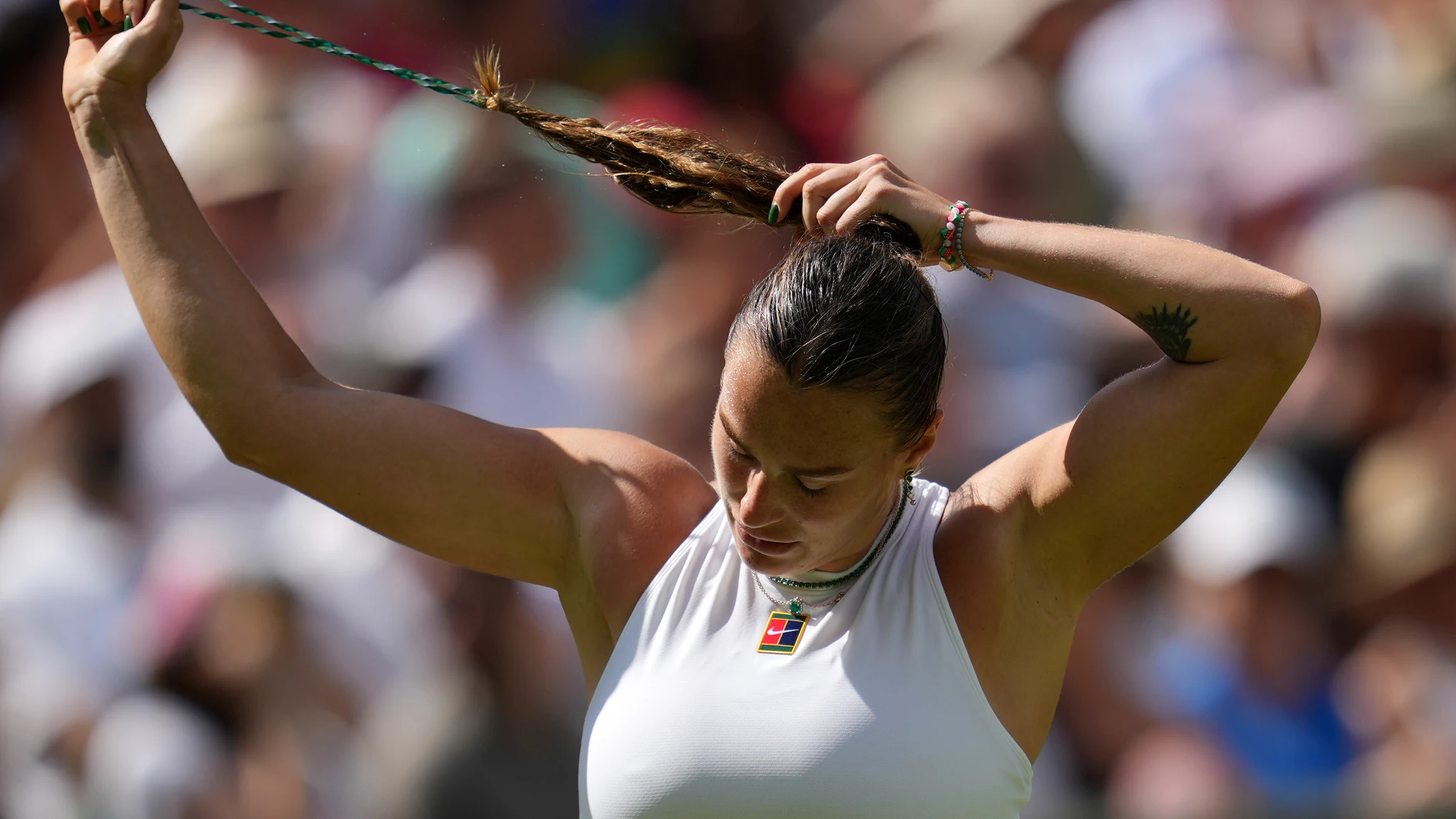 Aryna Sabalenka of Belarus adjusts her hair as she plays Amanda Anisimova of the U.S. during a women's singles semifinal match at the Wimbledon Tennis Championships in London, Thursday, July 10, 2025. (AP Photo/Kin Cheung)