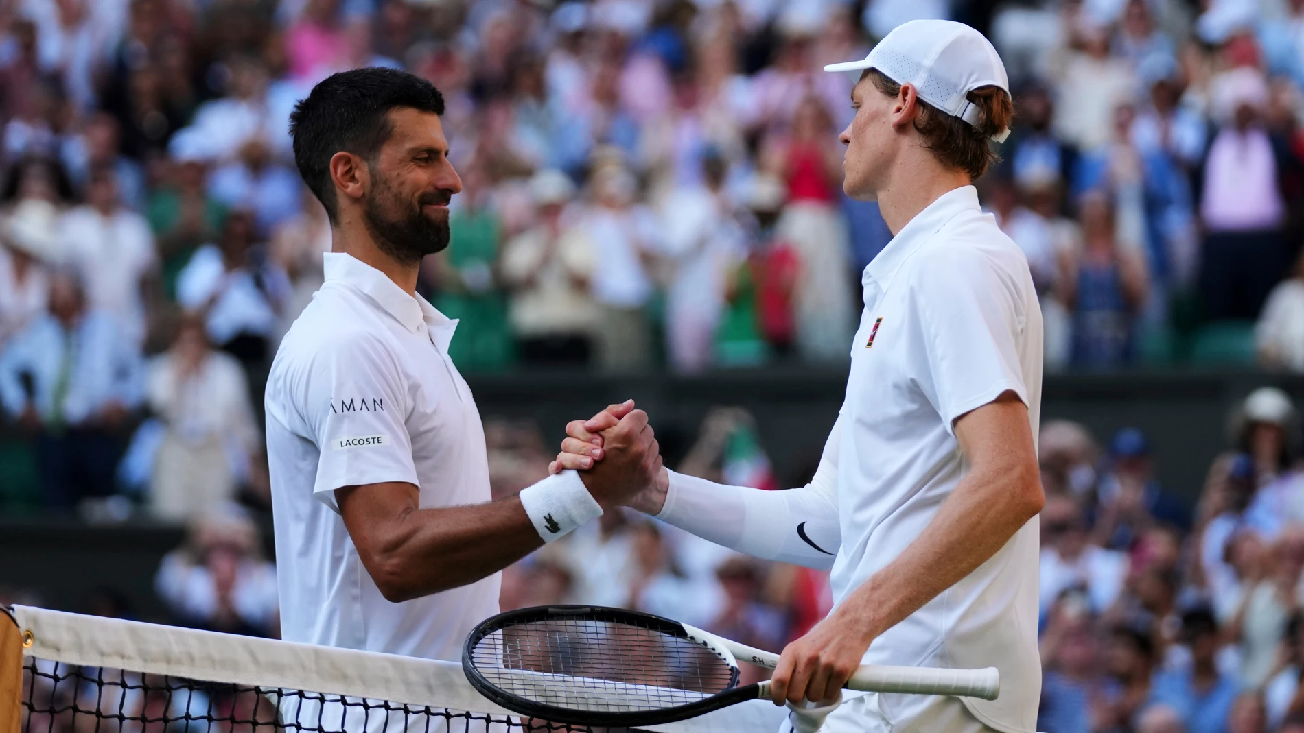 Jannik Sinner of Italy and Novak Djorkovic of Serbia shake hands after the men's semifinal singles match at the Wimbledon Tennis Championships in London, Friday, July 11, 2025.(AP Photo/Joanna Chan)