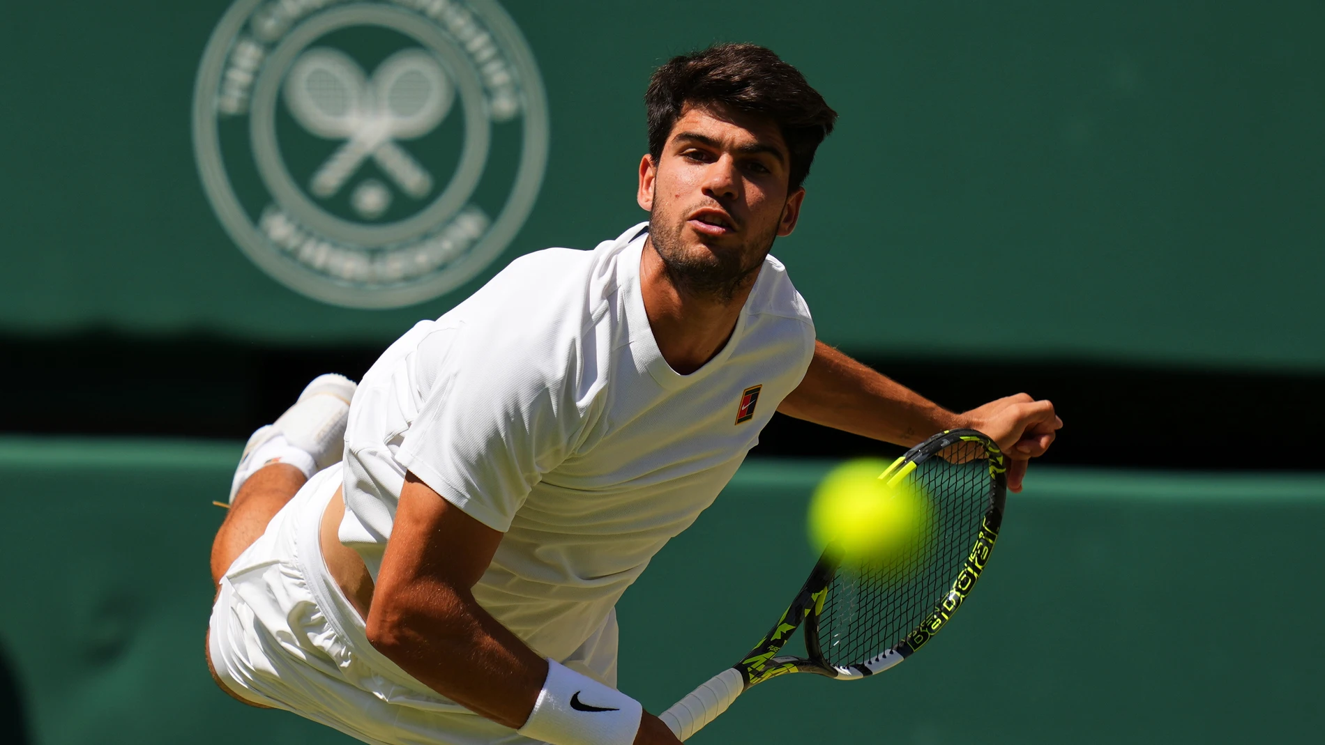 Carlos Alcaraz of Spain returns the ball to Taylor Fritz of the U.S. during the men's semifinal singles match at the Wimbledon Tennis Championships in London, Friday, July 11, 2025.(AP Photo/Kirsty Wigglesworth)