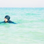 Una mujer bañándose con un burkini
