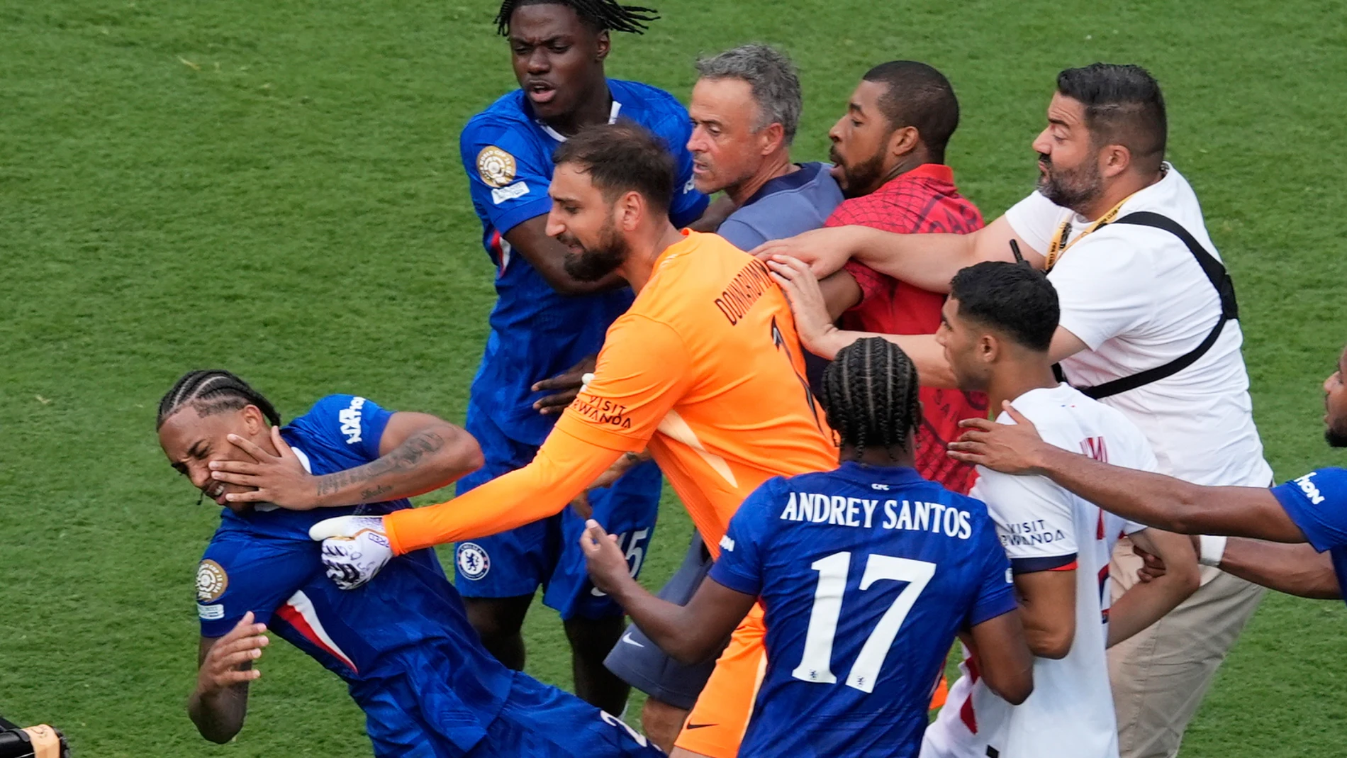 Chelsea's Joao Pedro, left, is attacked by Paris Saint-Germain's goalkeeper Gianluigi Donnarumma and coach Luis Enrique at the end of the Club World Cup final soccer match between Chelsea and PSG in East Rutherford, N.J., Sunday, July 13, 2025. (AP Photo/Pamela Smith)