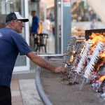  Un espetero le da la vuelta a un espeto de sardinas en un chiringuito de la capital de la Costa del Sol 