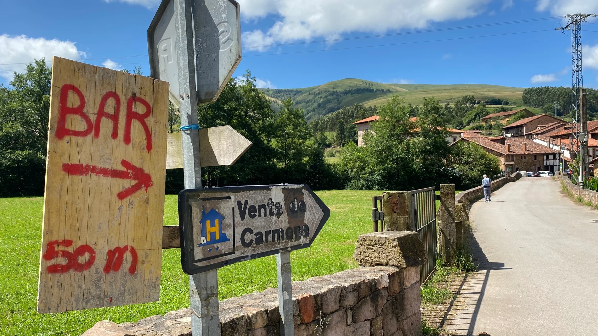 CABUÉRNIGA (CANTABRIA), 13/07/2025.- Imagen de la entrada de Carmona, en Cabuérniga (Cantabria), donde se indica con un cartel la presencia de un bar. En las grandes urbes los establecimientos de hostelería se cuentan por cientos o miles y los ciudadanos van de uno a otro casi en ruta, pero en los pueblos pequeños los bares -o, en muchos casos, el bar- son mucho más que un lugar en el que tomar el aperitivo o una bebida y constituyen el punto de encuentro para los vecinos.Estos pequeños bares...